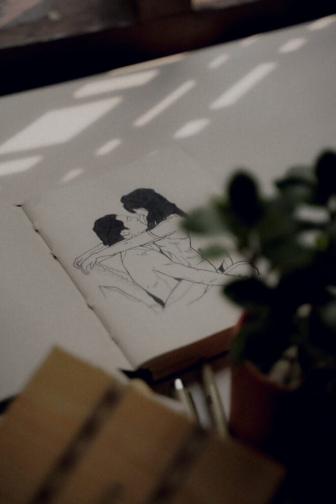 Intimate pencil sketch on paper with soft lighting and plant decor, creating a cozy artistic vibe.